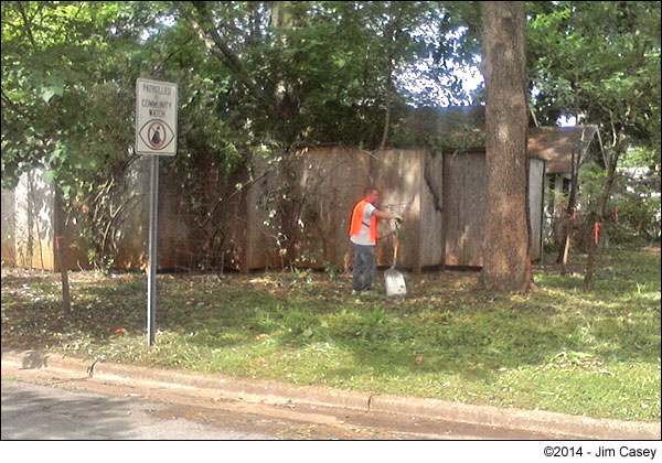 A city employee leans on his shovel will clearing James Hesslers yard.