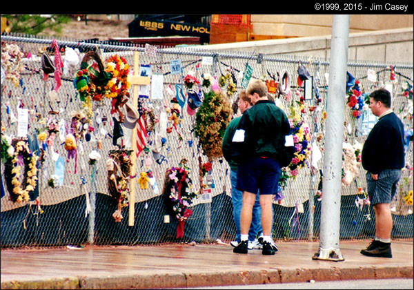 Flowers and mementos adorn a fence at the OKC memorial site.