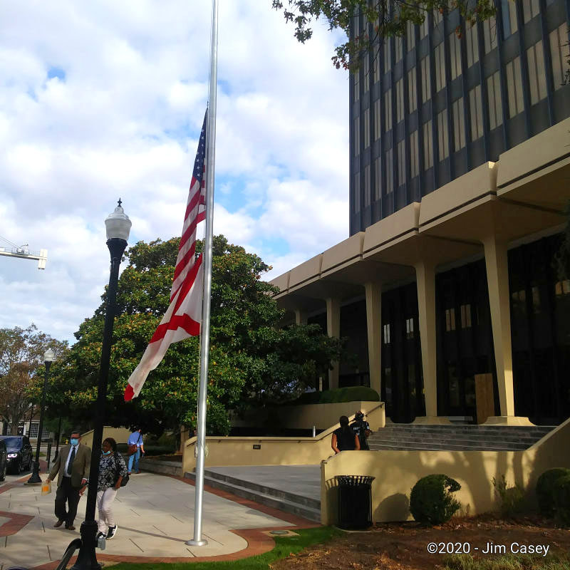 The flags fly at half staff in front of the Madison County Courthouse where an empty space remains in place of Huntsville's confederate monument. The flags have been lowered to honor Mayor Tommy Battles wife Eula, who will be laid to rest today, also in Maple Hill Cemetery.