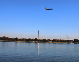 A colorful SouthWest airlines jet above the Washington Monument as seen from Arlington in October 2024.