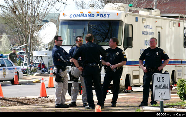 Police officers on the scene may appear relaxed but their mannerisms and persistent scanning indicate that they are constantly aware of everyone in the area.